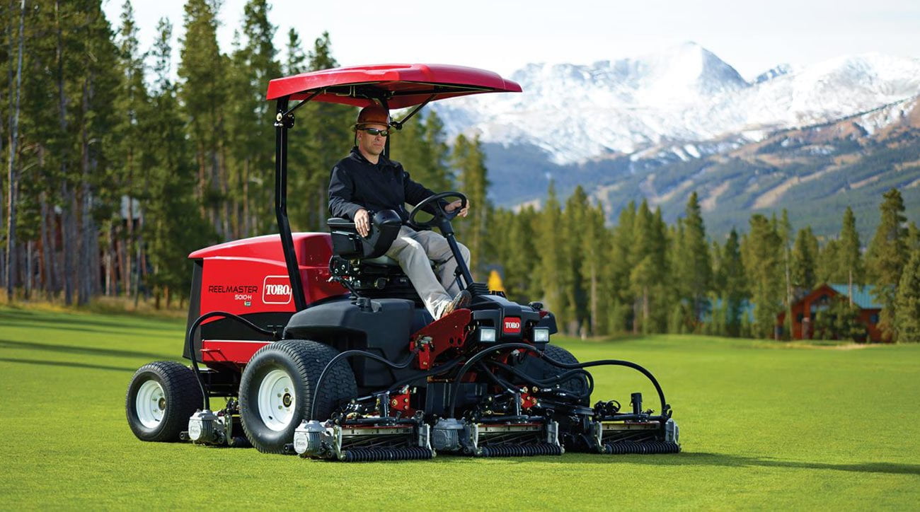 Lawnmower driven by man on lawn