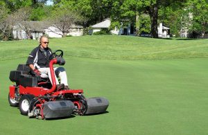 Man riding lawnmower on a manicured lawn