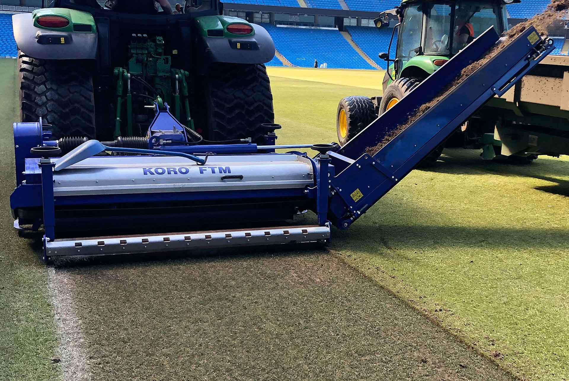machine cutting grass in stadium
